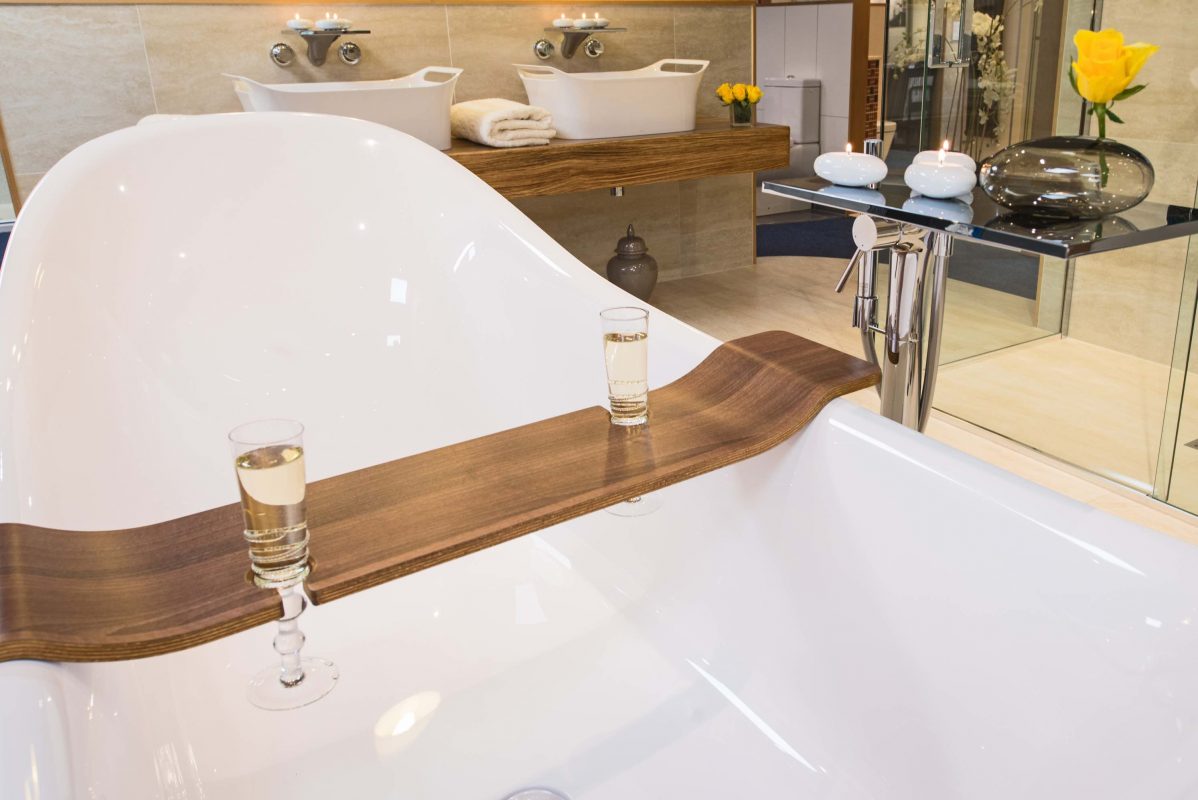 A ceramic bath with a wooden drinks holder