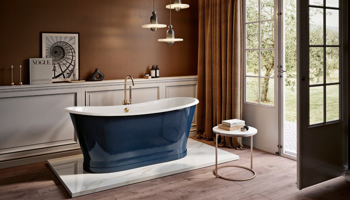 This modern bathroom features Imperial Bathroom products, including an elegant deep blue freestanding bath with a brass tap set against a brown wall and a large window.