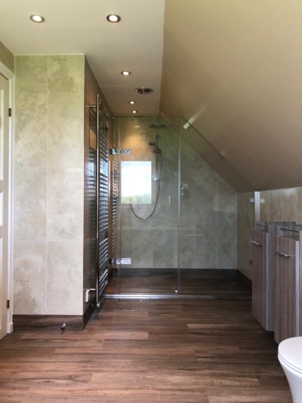 A completed bathroom, with open planned shower and sloping roof.
