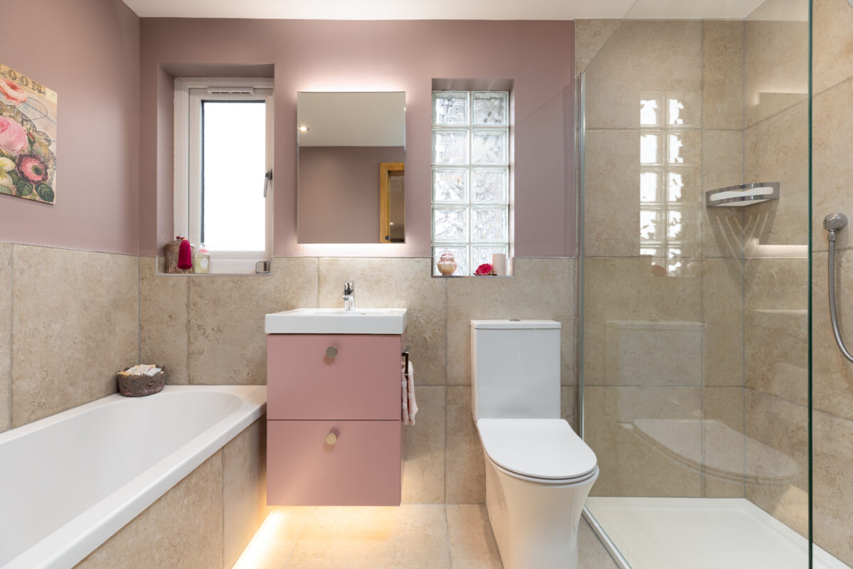 Bespoke bathroom renovation in Dundee showing a vanity unit in pink colour, WC, and a bath