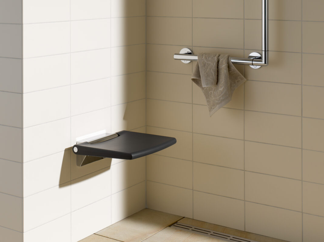 A foldable seat is installed in a walk-in shower for accessibility.