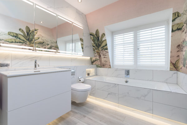Modern bathroom renovation in Edinburgh featuring a built-in bath, a white vanity unit, and wallpaper.
