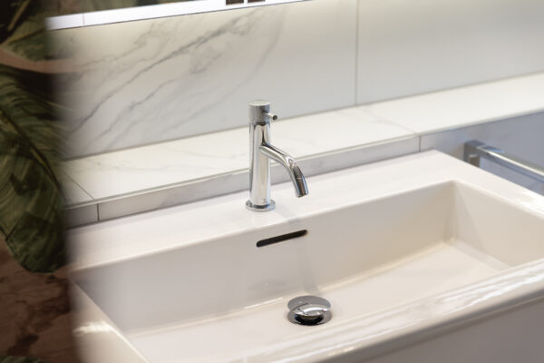 Close-up of a chrome tap and a white basin in a steam room renovation in Edinburgh.