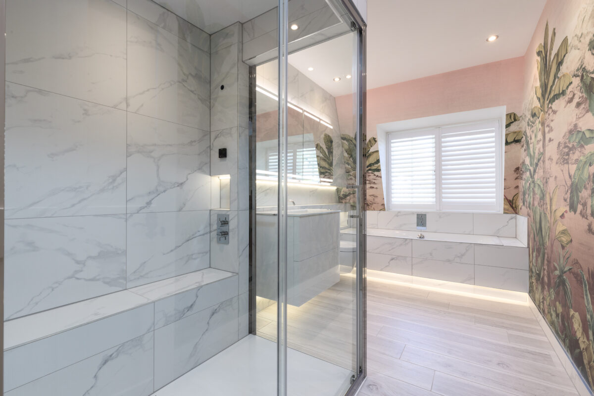 A steam room featuring a recess for storing bottles, a sitting area, and a shower enclosure. The steam room is fully tiled.