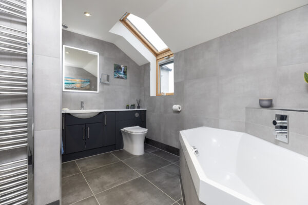 A larger modern bathroom with fitted bathroom furniture, a basin, and an integrated WC.