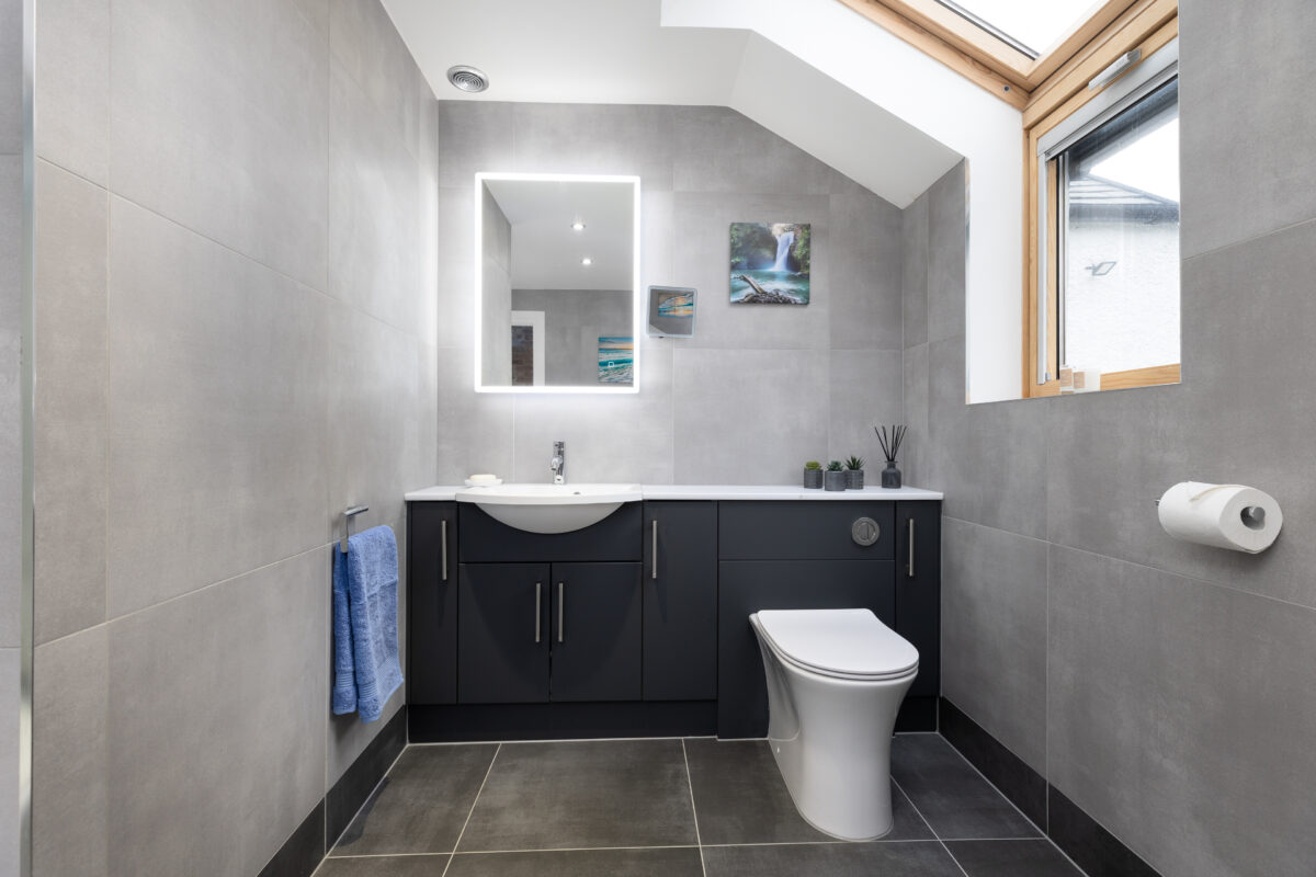 Fitted bathroom furniture with an integrated wash basin and WC. An LED illuminated mirror is placed above the vanity unit.