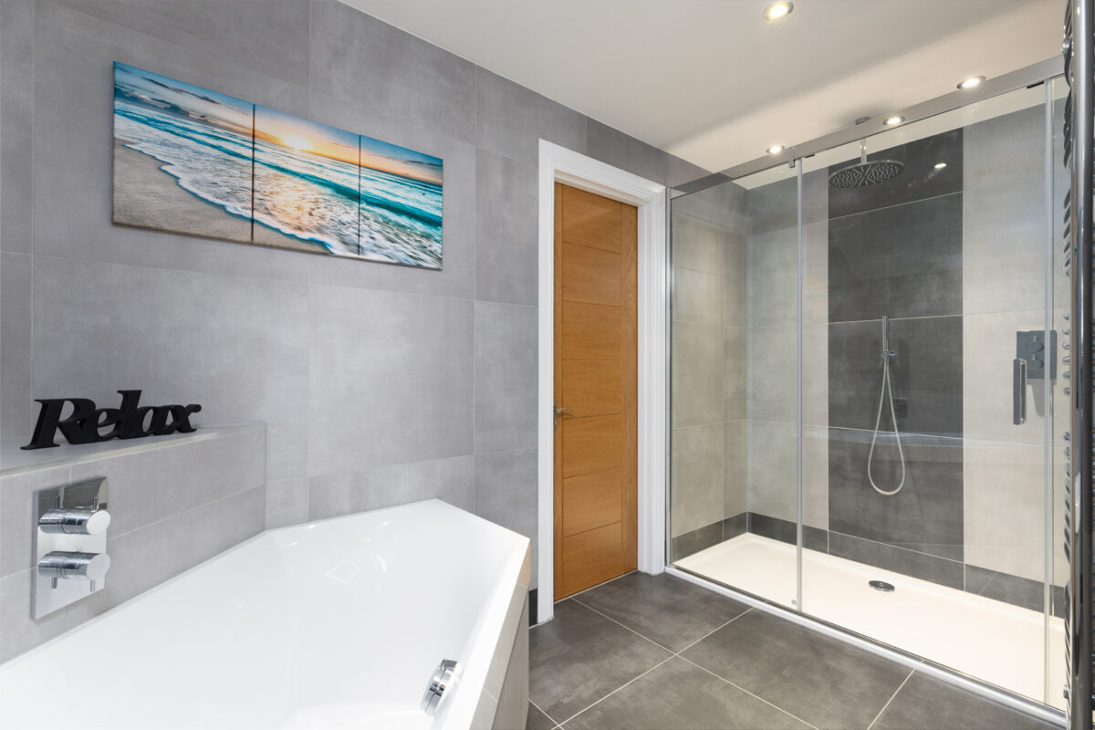 The bath and shower area of a modern bathroom renovation in Perthshire with chrome fixtures.