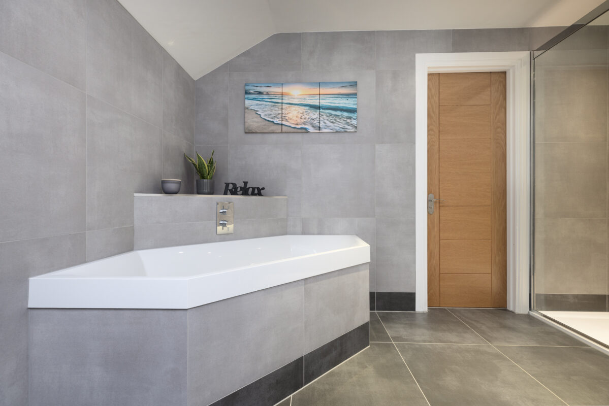 A bathing area in a contemporary bathroom in Perthshire featuring a bulkhead for storage and decorative items.