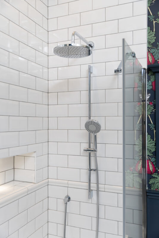 A shower area with a shower system and a recessed shelf to complete the traditional bathroom installation in Edinburgh.