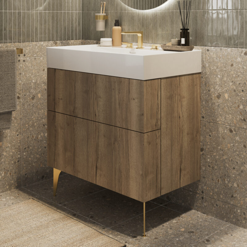 A close-up image of a free-standing vanity unit featuring a brushed brass leg and a brushed brass mixer.