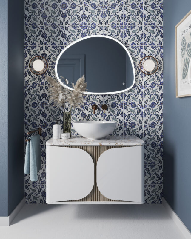 A wall-mounted vanity unit in a matte white finish features a basin on top. Above the vanity is a wall-mounted mixer in brushed brass, complemented by a large illuminated mirror.