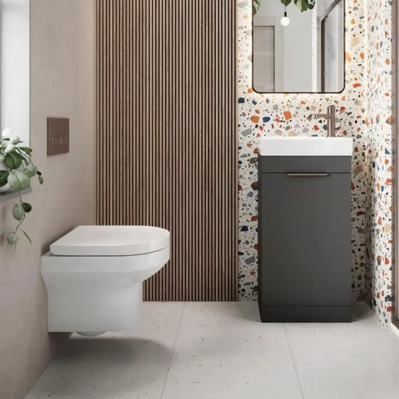 A spacious cloakroom features a floor-mounted vanity unit and a basin fitted with a brushed brass mixer. A large mirror is positioned above the vanity unit.