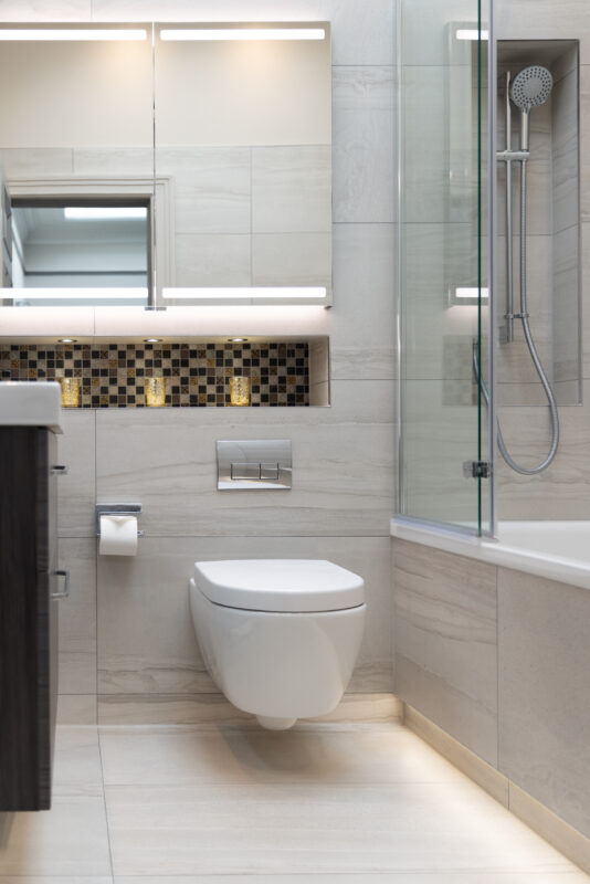 Fully tiled bathroom with a WC and shower over bath style installed as part of a whole home renovation in Edinburgh.