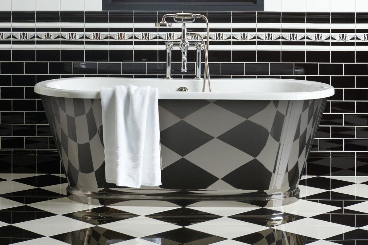 A freestanding bath on unique traditional black and white checkerboard tiles.