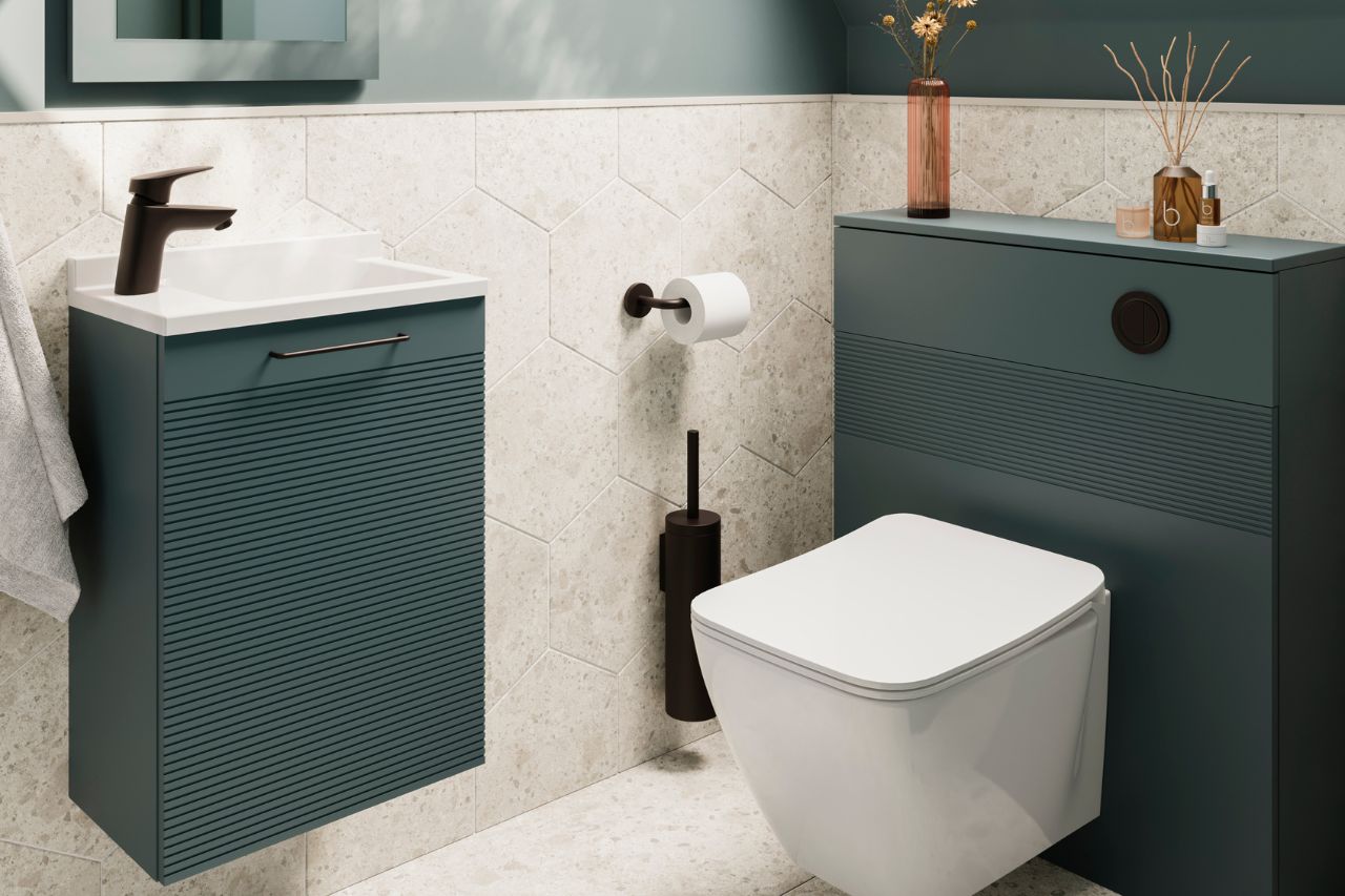 A well-planned cloakroom layout that includes a vanity unit with a mirror above it and a hung WC with furniture for storage.