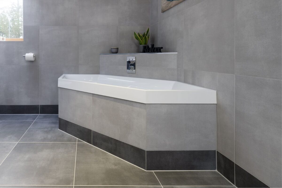 A built-in hexagonal bath with a bulkhead that serves as storage for decorative items.