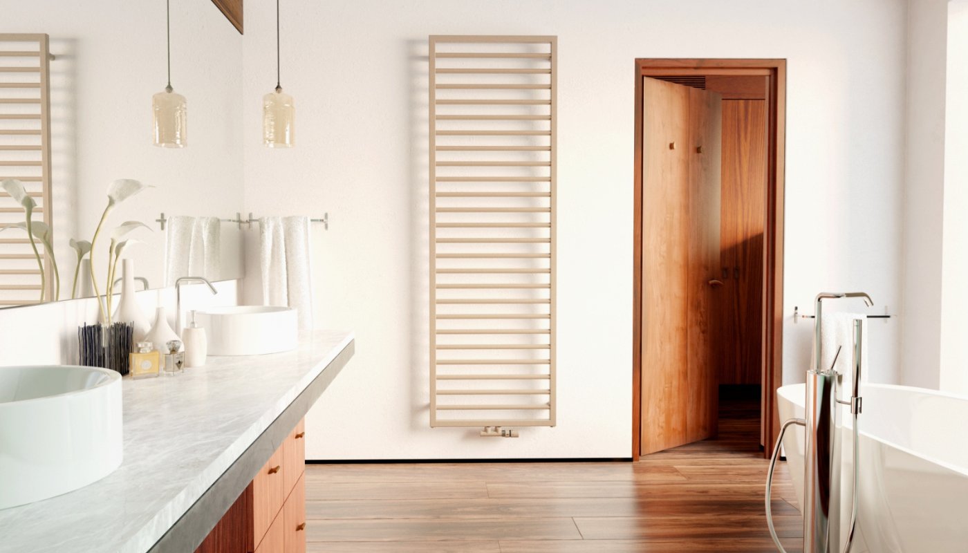 A large heated towel rail in brushed brass and a freestanding bath in a modern-style bathroom.