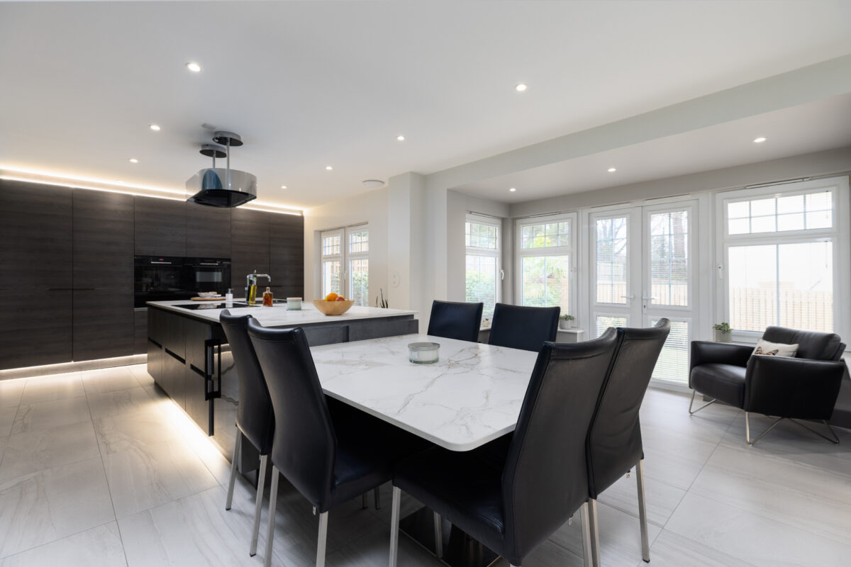 A spacious kitchen with an island and a dining area with a large kitchen cabinet with integrated kitchen appliances