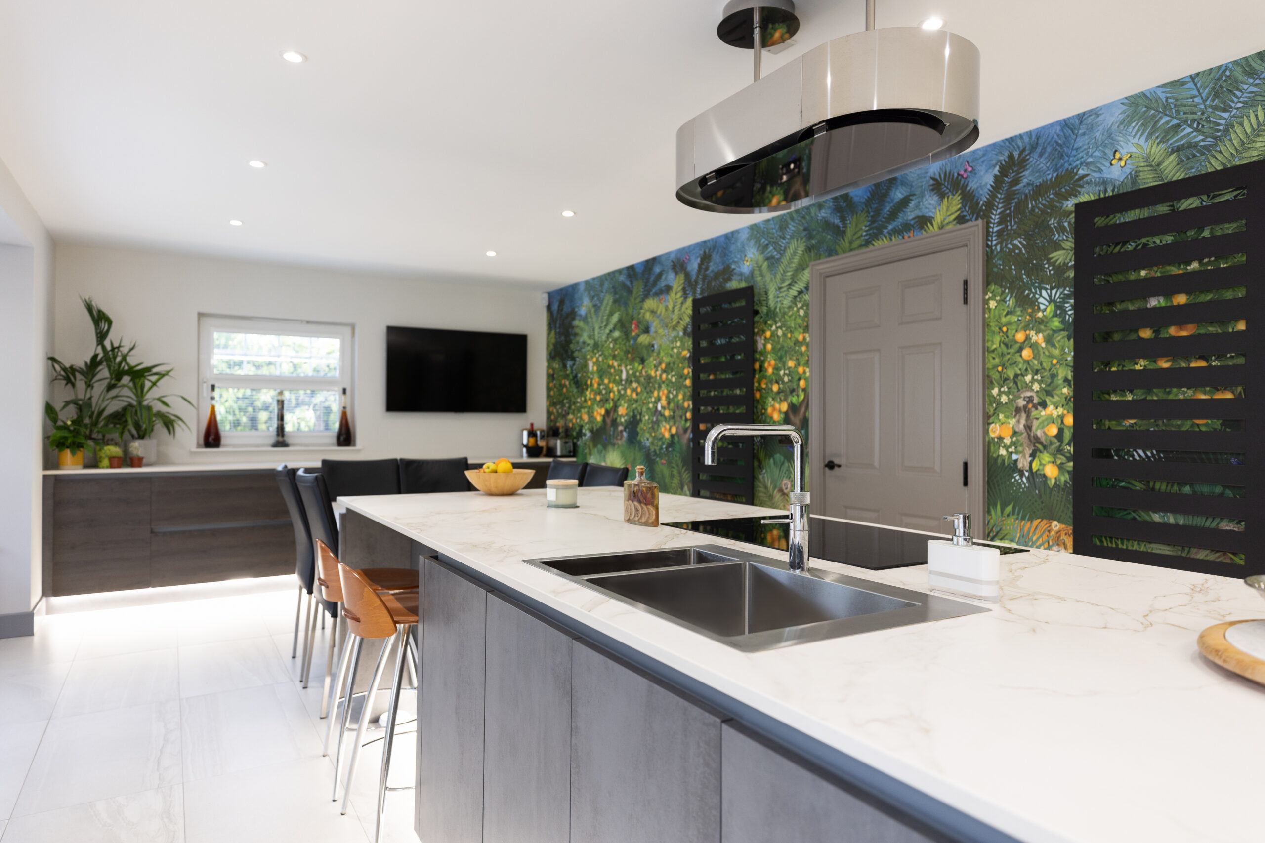 A modern kitchen as part of a full home renovation in Edinburgh. It features an island with a Dekton worktop, a hob, and a dining area.