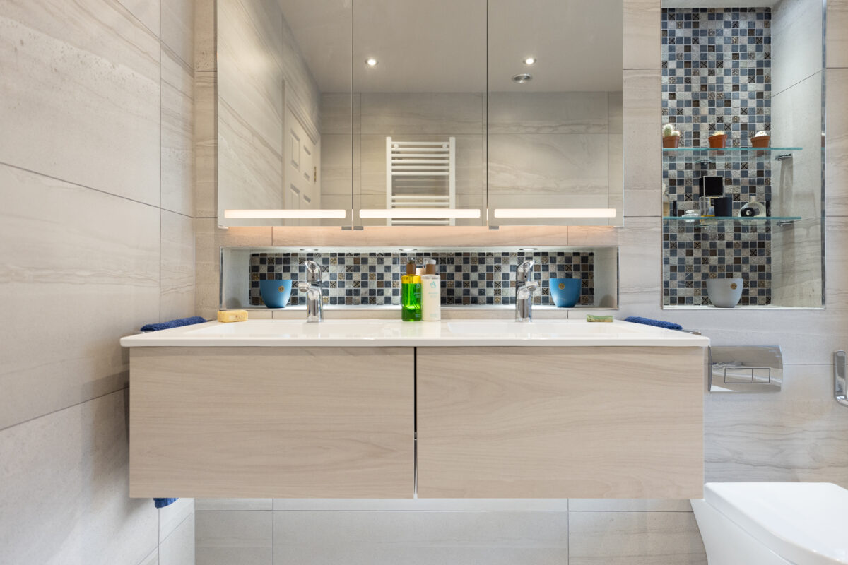 A large vanity area with a dual drawer basin vanity unit, topped with a large three-door mirror cabinet, as part of a family bathroom renovation within a whole home renovation project.