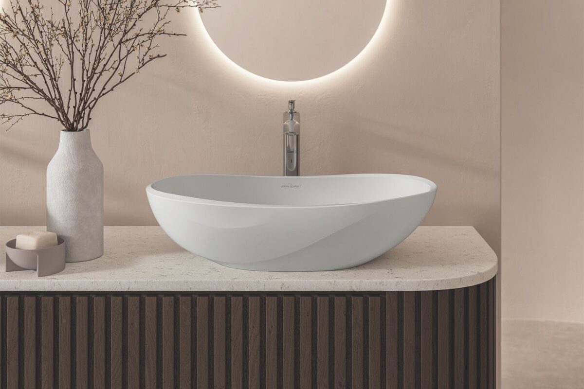 A modern vanity area with a wash basin on a fluted vanity with a worktop and a backlit mirror, complemented by a wall painted splashback.