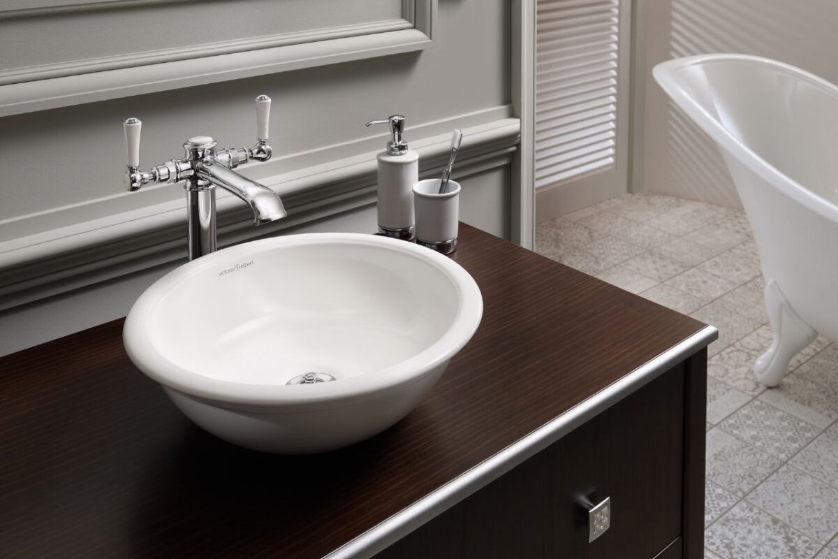 Wood panels serving as a splashback and a floor-mounted mixer with a white basin.