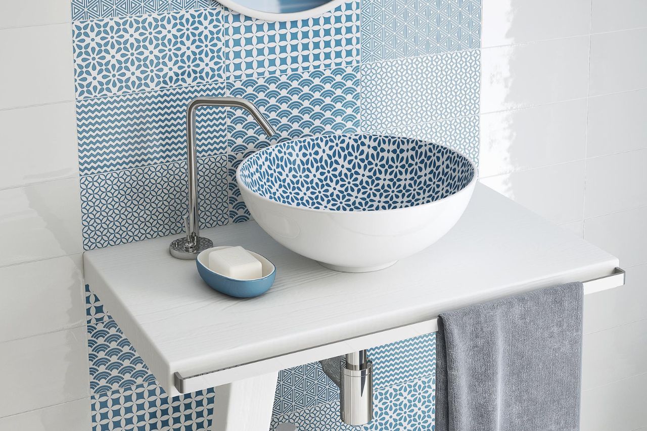 A patterned washbasin with a splashback in blue and white colours