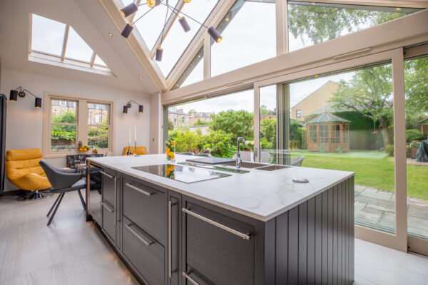 Modern kitchen island featuring a Quooker tap, integrated hob, and downdraft extractor, with generous storage throughout, as part of a beautifully designed kitchen extension in Edinburgh.