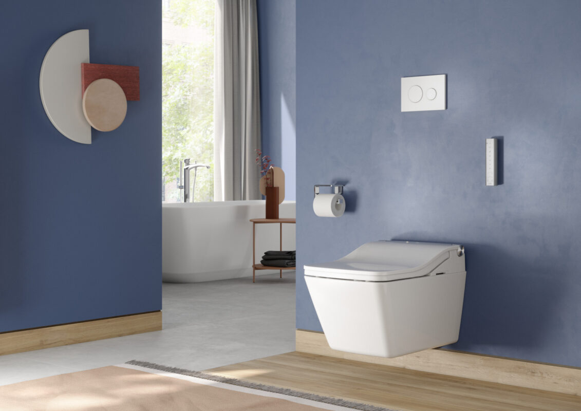 The WASHLET toilet from TOTO is wall-mounted in a contemporary bathroom. Above it is the flush plate and the remote control for easy use.